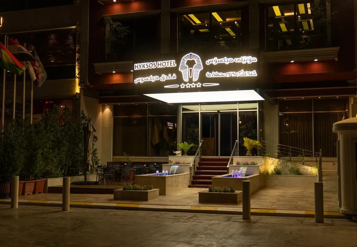 Hyksos Hotel facade with trilingual signage lit at night in Ankawa, Erbil